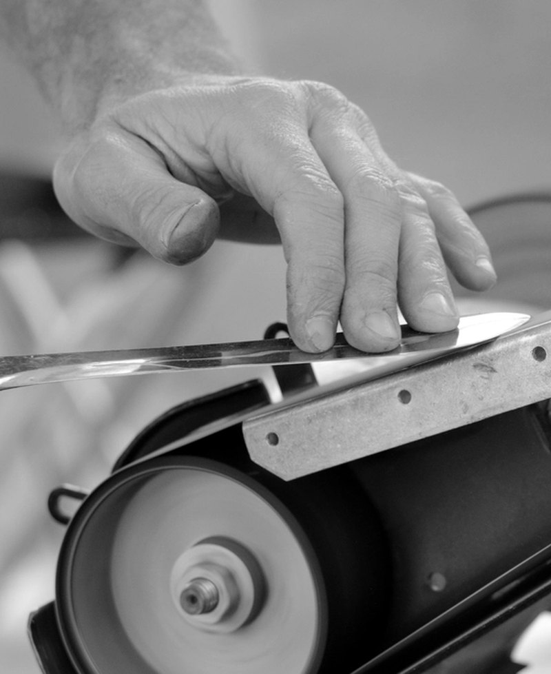 Ray Calloway's hands setting a bevel on the grinding wheel in the Modular Ready workshop